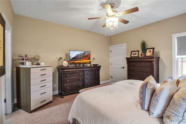 bedroom with ceiling fan, light carpet, and baseboards