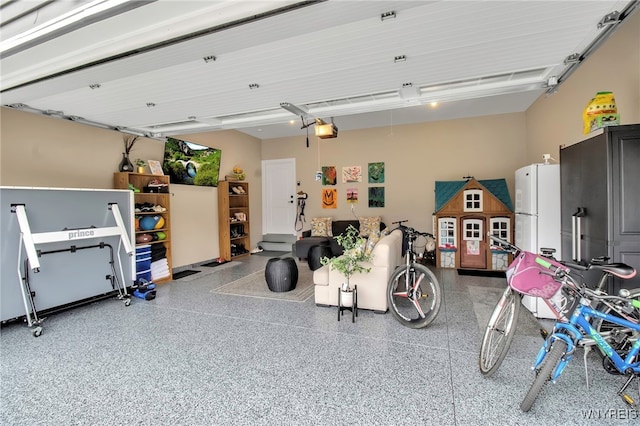 garage featuring a garage door opener and freestanding refrigerator