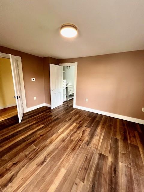interior space featuring baseboards and dark wood-type flooring