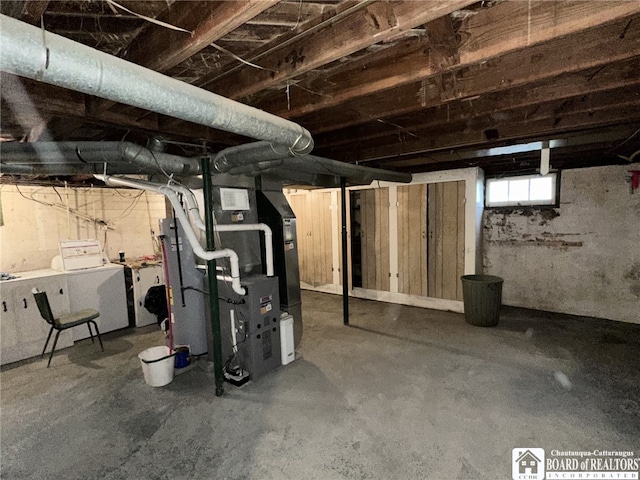 basement featuring heating unit, visible vents, and independent washer and dryer