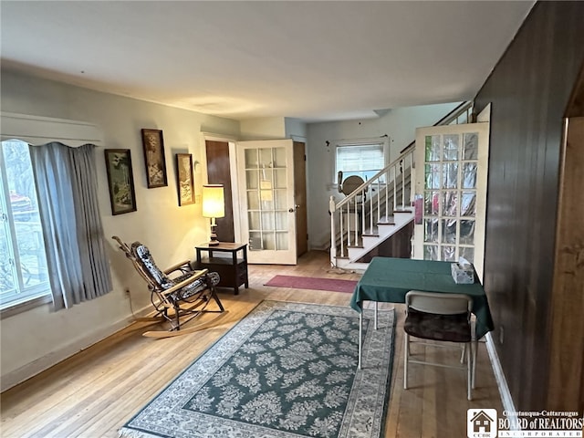 living area featuring stairway, a healthy amount of sunlight, and wood finished floors