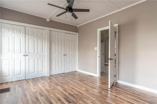 620 W St, Wilna, NY 13619 - unfurnished bedroom with two closets, visible vents, crown molding, and wood finished floors