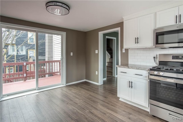 620 W St, Wilna, NY 13619 - kitchen featuring baseboards, tasteful backsplash, wood finished floors, and stainless steel appliances