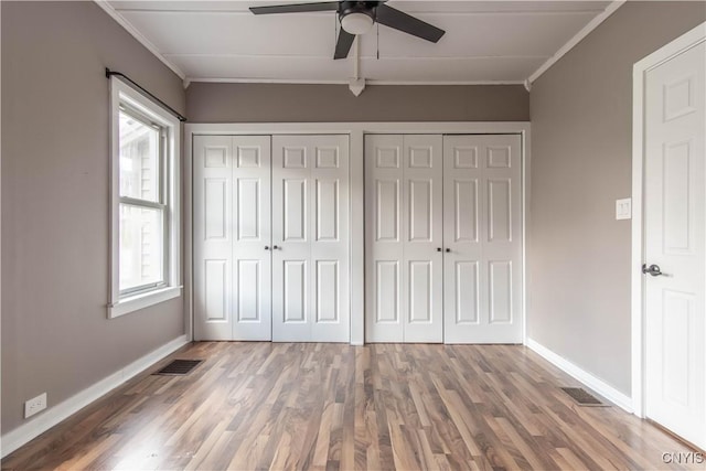 620 W St, Wilna, NY 13619 - unfurnished bedroom with two closets, baseboards, crown molding, and visible vents