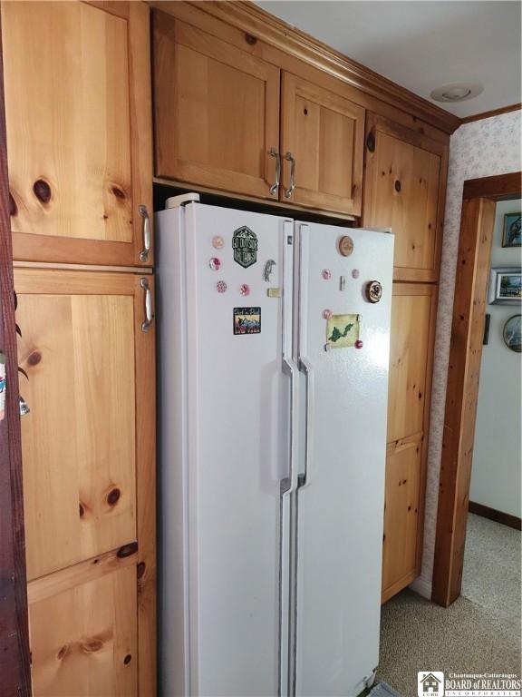 kitchen featuring brown cabinets and freestanding refrigerator