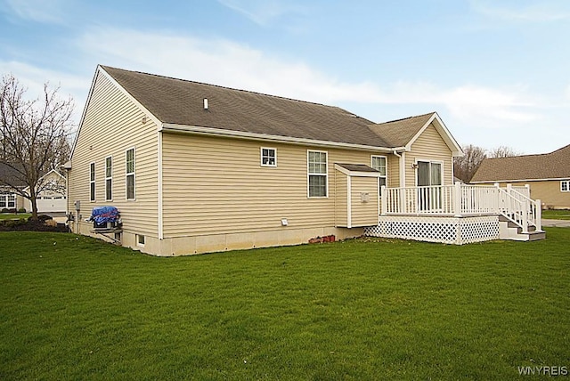 back of house featuring a wooden deck and a lawn