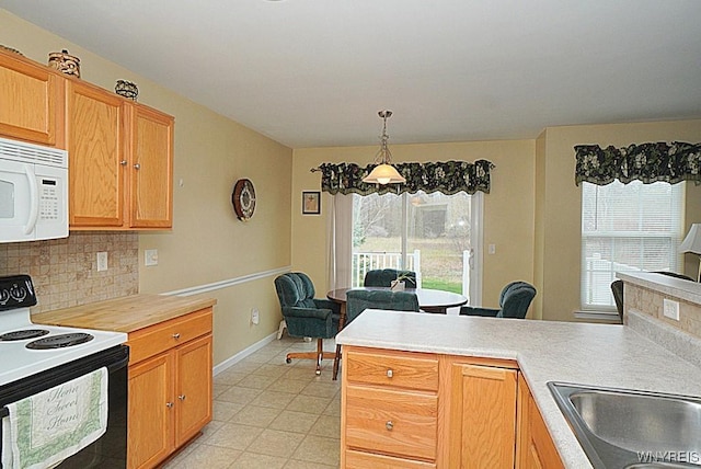 kitchen featuring white microwave, backsplash, pendant lighting, electric range oven, and light countertops