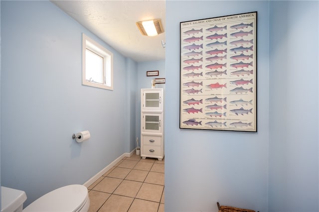 bathroom with toilet, tile patterned floors, and baseboards