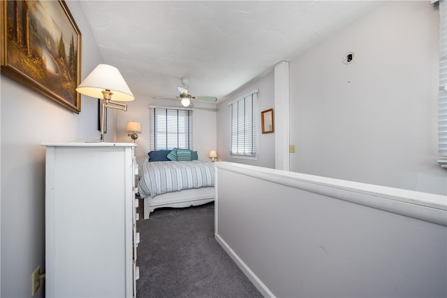 bedroom with dark carpet and baseboards