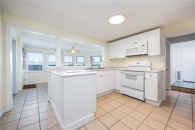 kitchen with white cabinets, light countertops, a sink, light tile patterned flooring, and white appliances