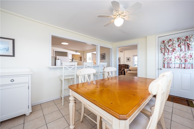 dining area featuring ceiling fan, baseboards, and light tile patterned floors