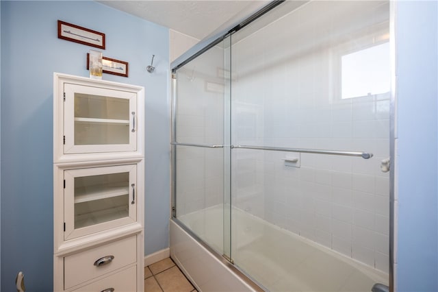 bathroom featuring tile patterned flooring and combined bath / shower with glass door