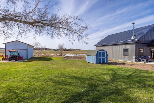 view of yard featuring a garage, an outbuilding, and a storage shed