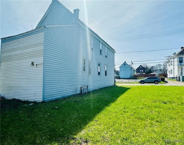 view of property exterior with a lawn and a chimney
