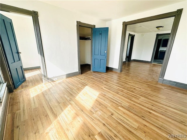 unfurnished room with baseboards and light wood finished floors
