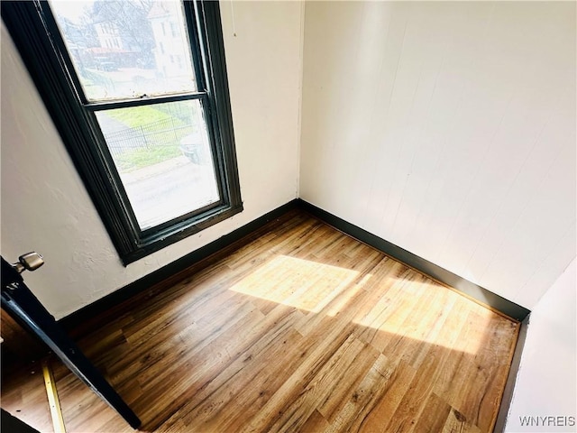 unfurnished room featuring baseboards and wood finished floors