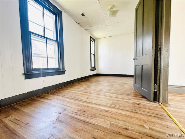 spare room with light wood-style floors, baseboards, and visible vents