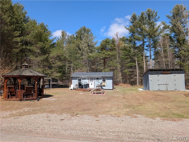 view of yard with a gazebo, a storage shed, and an outdoor structure
