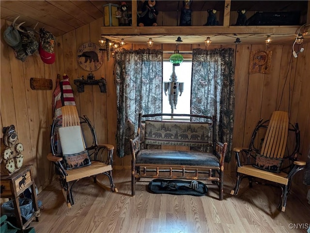 sitting room featuring wooden ceiling, vaulted ceiling, wood finished floors, and wooden walls