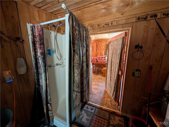 full bath with wood walls and a shower with shower curtain