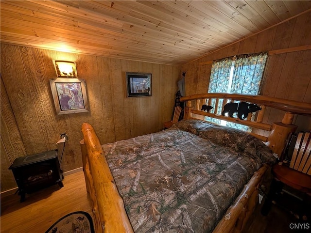 bedroom featuring lofted ceiling, wooden walls, wood finished floors, and wood ceiling