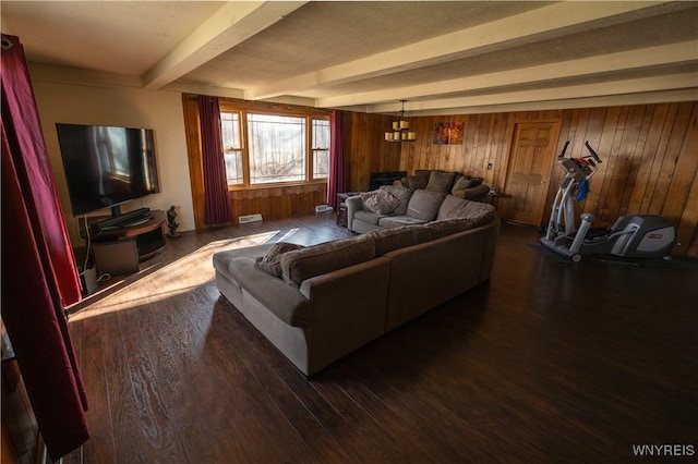 living area featuring wood walls, visible vents, beamed ceiling, and dark wood finished floors