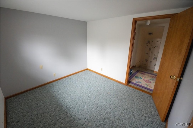 spare room with baseboards and carpet floors