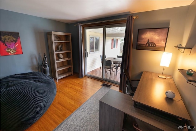 bedroom featuring light wood finished floors, access to exterior, and visible vents