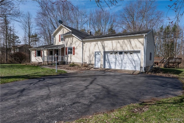 exterior space with a front lawn, a garage, covered porch, and aphalt driveway