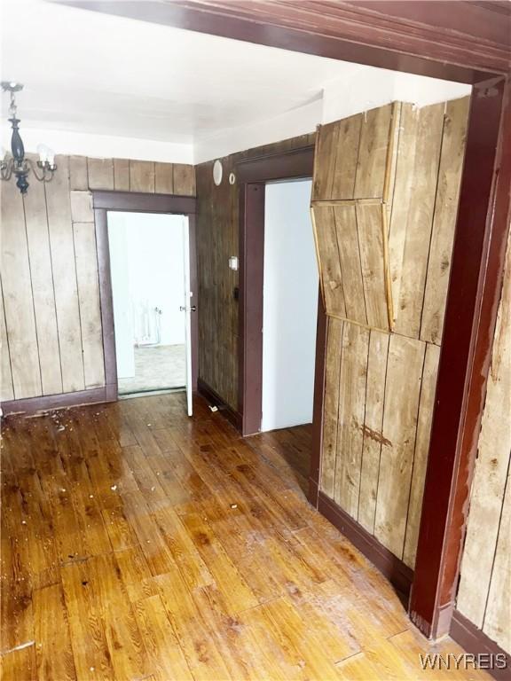 720 Sherman St, Buffalo, NY 14211 - spare room featuring hardwood / wood-style flooring, a chandelier, and wooden walls