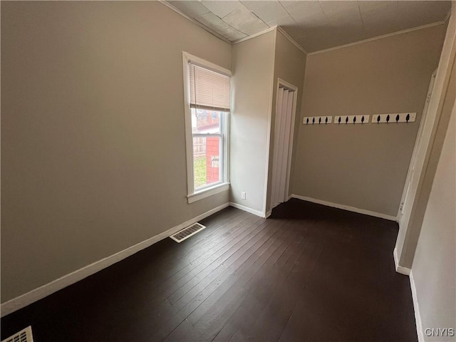 unfurnished bedroom featuring visible vents, crown molding, baseboards, and dark wood-style flooring