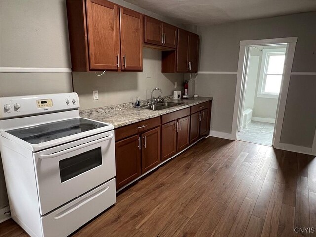 kitchen featuring baseboards, white electric range, a sink, and dark wood-style flooring