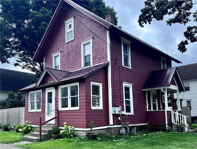 view of front facade with fence, entry steps, and a front yard