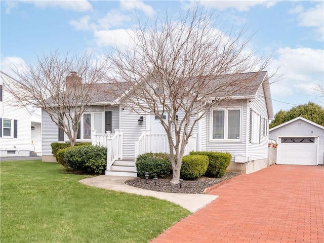 bungalow-style home with an outbuilding, a front lawn, a chimney, a garage, and decorative driveway