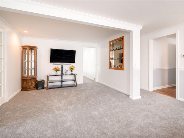 unfurnished living room with carpet floors, baseboards, and ornamental molding