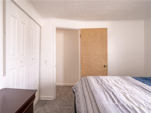 bedroom with baseboards, carpet flooring, a closet, and crown molding