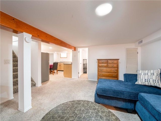 living area featuring baseboards, visible vents, stairs, and light carpet