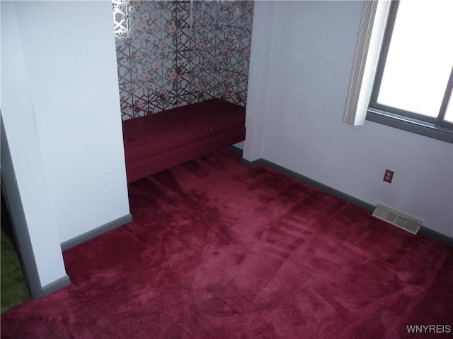empty room featuring baseboards, carpet flooring, and visible vents