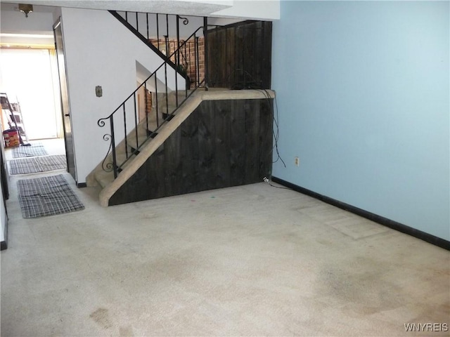 interior space featuring baseboards, carpet floors, and stairs