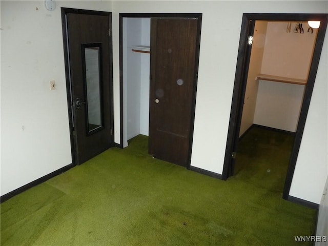 unfurnished bedroom featuring baseboards, carpet flooring, and a closet