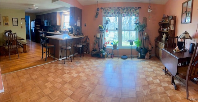 330 Hacadam Rd, Frankfort, NY 13456 - kitchen featuring stainless steel microwave, freestanding refrigerator, a breakfast bar, tasteful backsplash, and a peninsula