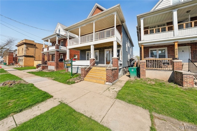 townhome / multi-family property with covered porch, a balcony, and brick siding