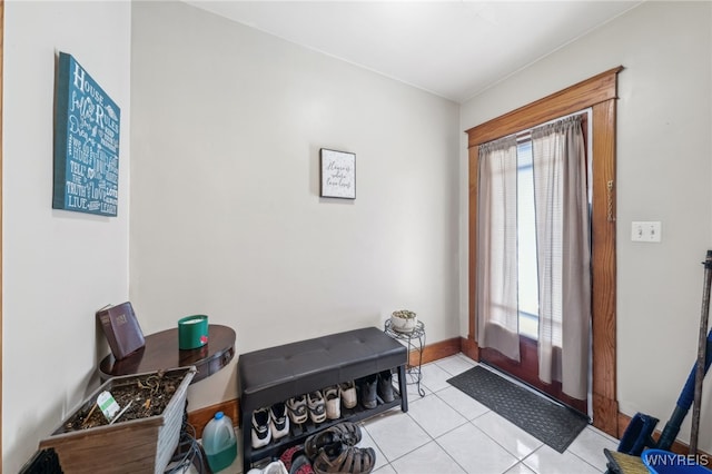 doorway to outside with baseboards, light tile patterned floors, and a wealth of natural light