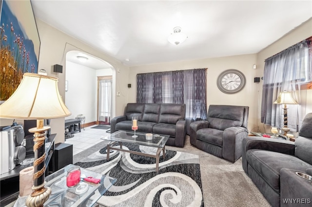 living area featuring arched walkways and carpet flooring