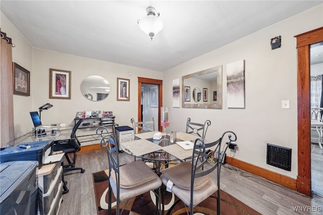 dining room with wood finished floors, visible vents, and baseboards