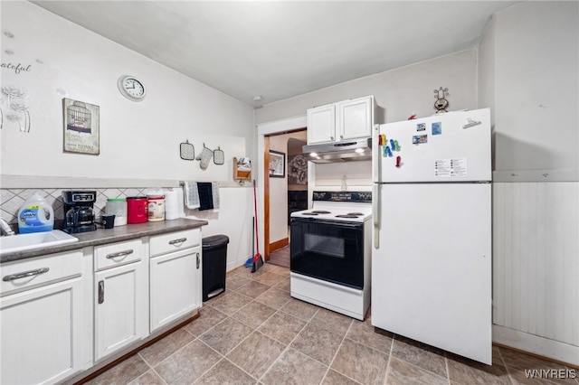 kitchen with a sink, under cabinet range hood, white cabinetry, range with electric stovetop, and freestanding refrigerator