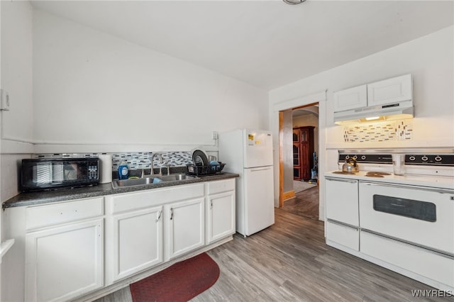 kitchen featuring white cabinetry, a sink, under cabinet range hood, light wood finished floors, and white appliances