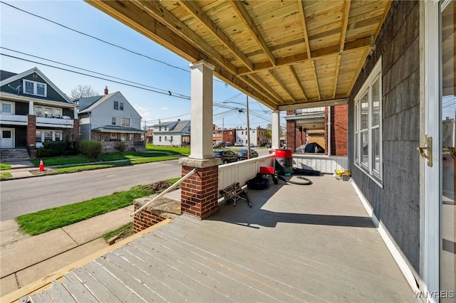wooden terrace with covered porch and a residential view