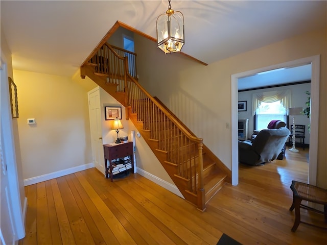 658 Cornell Rd, Elmira-City, NY 14905 - staircase featuring hardwood / wood-style flooring, baseboards, and a chandelier