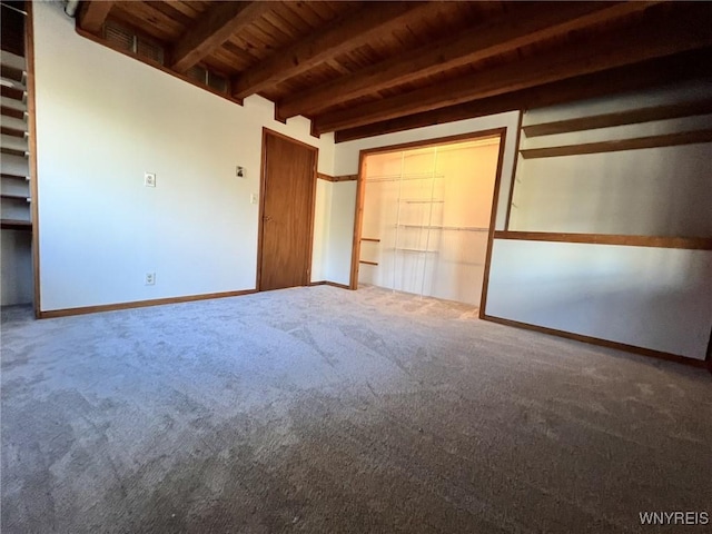 unfurnished bedroom featuring wooden ceiling, baseboards, beam ceiling, and carpet